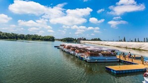 A calm river with a series of floating platforms, each with a covered seating area and life rings. - Longshui Lake Dalong Bay Hotel (Chongqing)