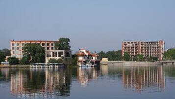 A calm lake with buildings reflecting on the water.