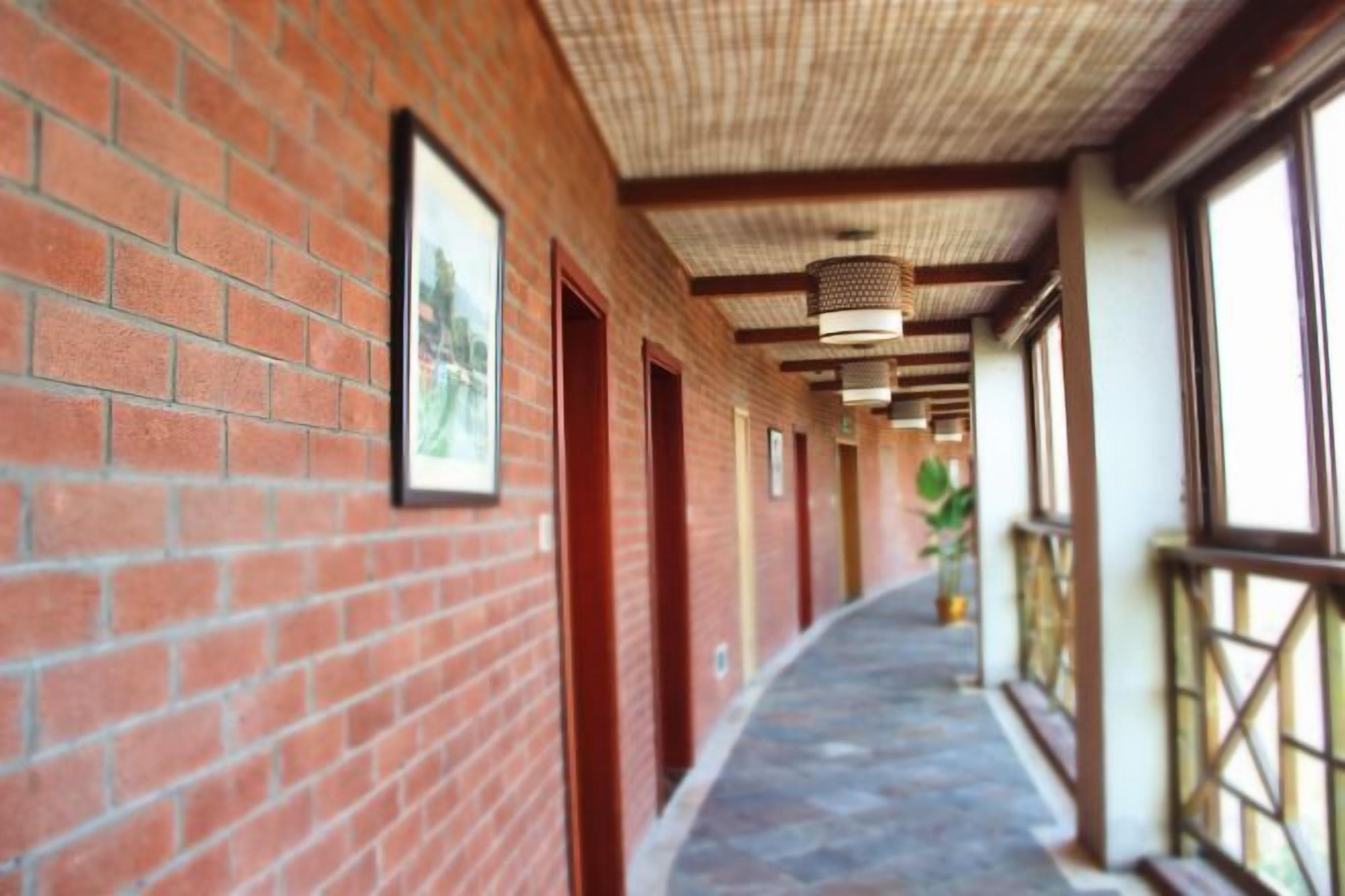 Un pasillo con paredes de ladrillo, puertas y un techo con diseño.