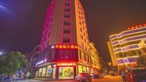 A hotel with a prominent vertical sign, multiple floors, and illuminated windows.