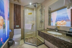 A bathroom with a glass-enclosed shower, a marble sink, and a toilet.
