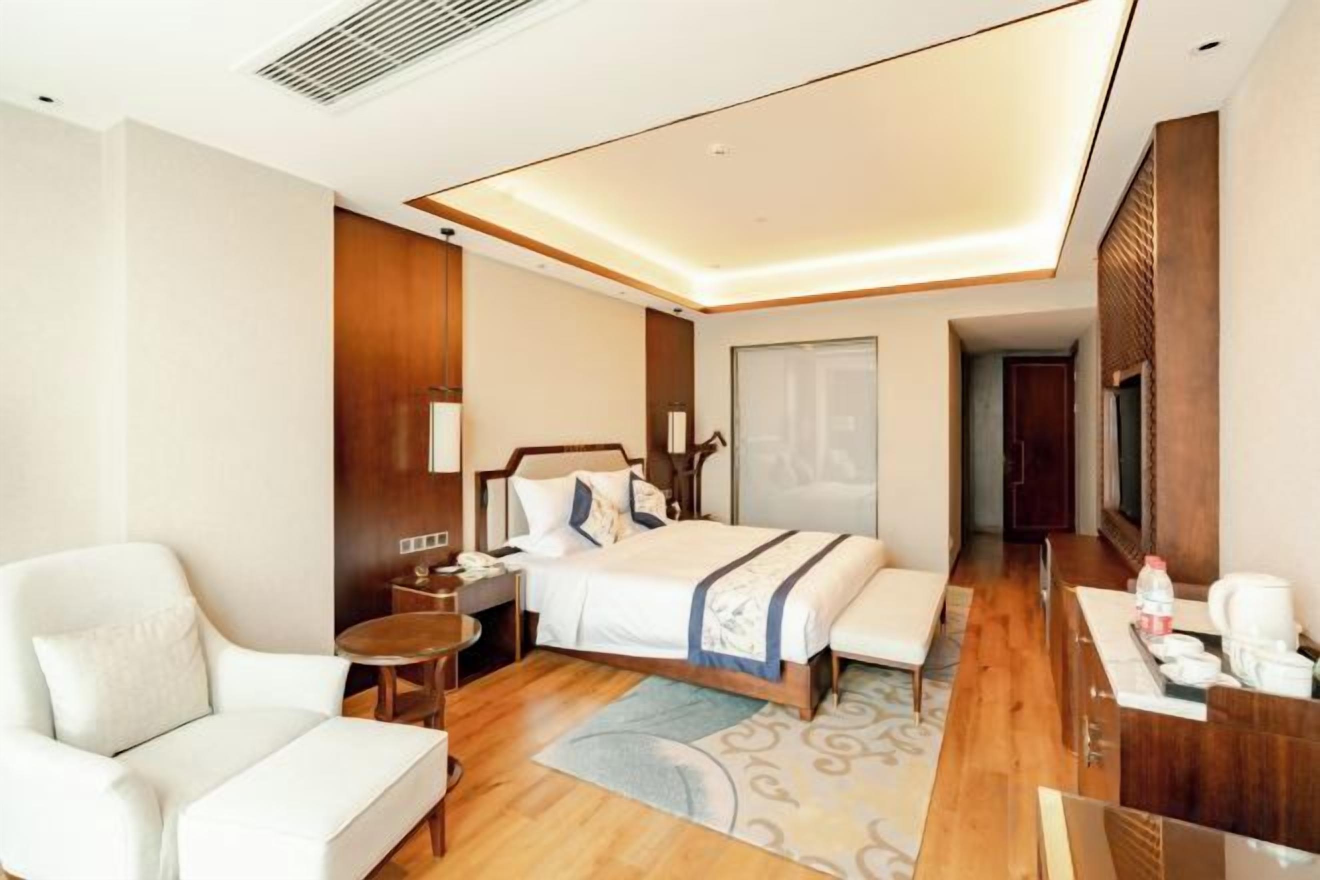 Ein Hotelzimmer mit Bett, Sitzecke, Schreibtisch und Fernseher.