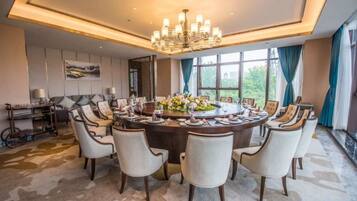 A formal dining room with a round table, multiple chairs, and a chandelier.