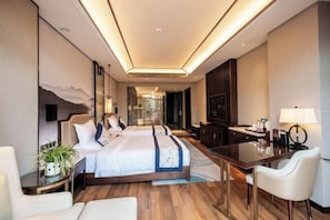 A modern hotel room with a large bed, a desk, and a seating area. - Jinyang Shangcheng Hotel (Jintang)