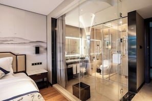 A modern hotel room with a glass-enclosed shower, a bed with a headboard, and a nightstand. - Jinyang Shangcheng Hotel (Jintang)