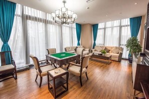 A room with a pool table, sofas, and a chandelier. - Jinyang Shangcheng Hotel (Jintang)