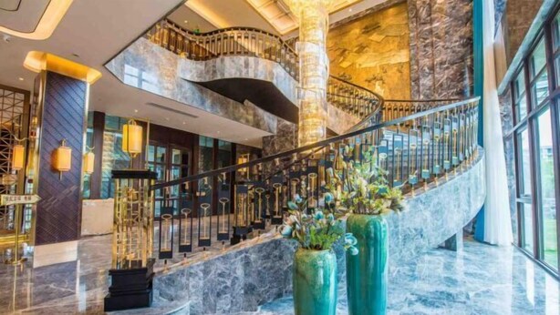 A grand hotel lobby with a marble staircase, large vases, and a high ceiling. - Jinyang Shangcheng Hotel (Jintang)