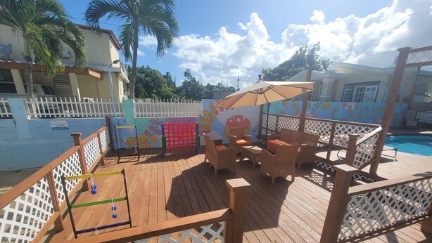 A wooden deck with outdoor furniture and a pool. - Apt w/ Pool Deck & Games, 5 mins From The Beach- CU (Isabela)