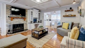 A spacious living room with a fireplace, a television, and a sofa.