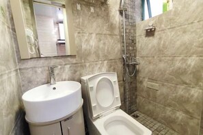 Un baño con lavamanos, inodoro y ducha.