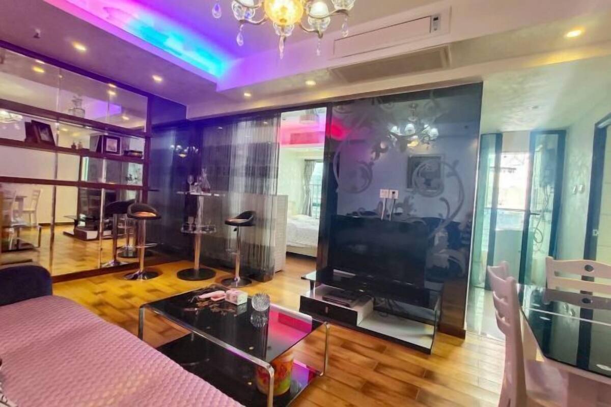 Un salon moderne avec une cloison en verre, un téléviseur et une table basse.