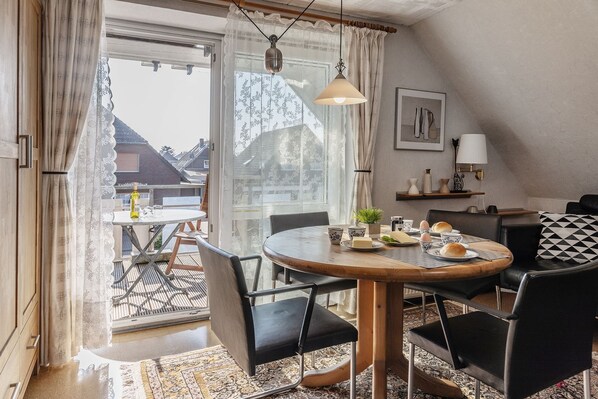 A cozy dining area with a round table, black chairs, and a view of the outside.