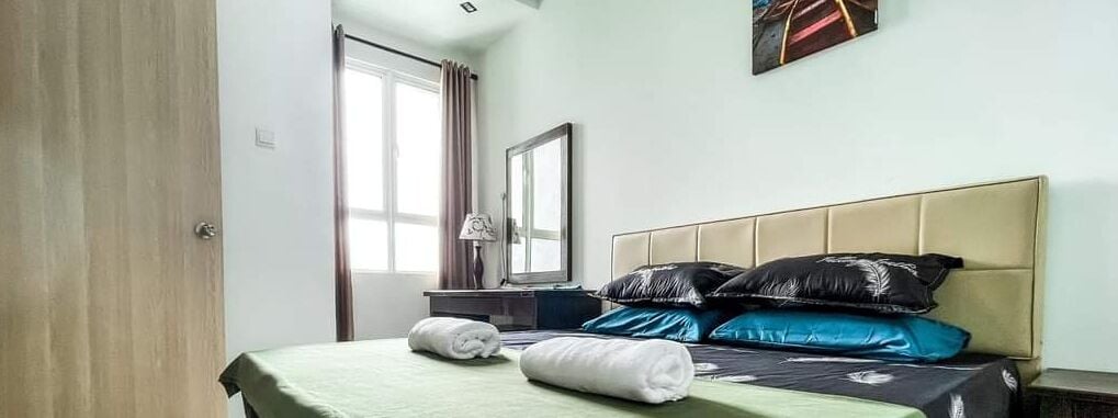 Une chambre d’hôtel avec un lit, une table de chevet, une lampe, une fenêtre avec des rideaux et un miroir au mur.