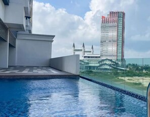 Une piscine sur le toit offrant une vue dégagée sur une mosquée et un grand immeuble en arrière-plan.