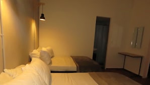 A bedroom with a bed, bedside table, and a mirror on the wall.