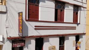 Un edificio de dos pisos con un letrero que dice "HOSTAL".