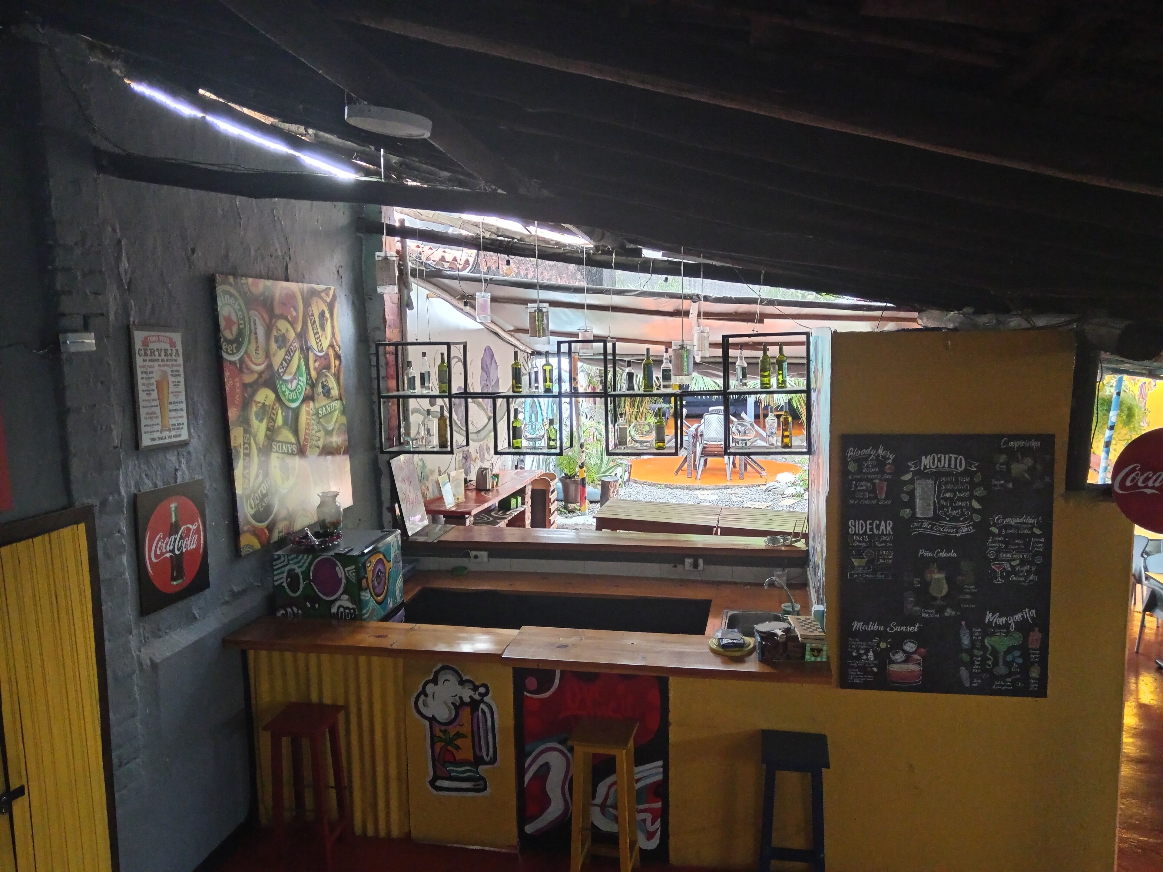 A bar area with a counter, stools, and a menu board.