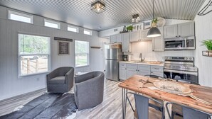 A spacious kitchen with modern appliances, a dining area with a wooden table, and a cozy seating area with chairs.