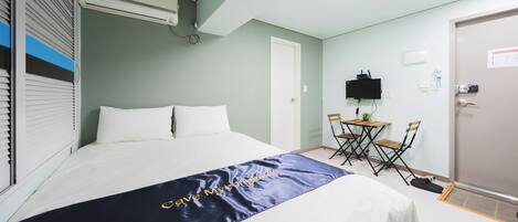 Una habitación de hotel con una cama, un escritorio y un televisor.