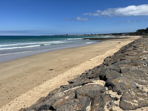 A beach with a rocky shoreline and a clear view of the ocean.