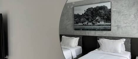 Una habitación de hotel moderna con una cama grande, dos mesitas de noche y un televisor montado en la pared.
