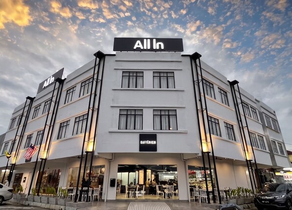 A multi-story building with a sign reading 'All In' and 'CAFÉRIEM' indicating a café or restaurant.