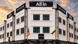Un hotel con señalización 'All In', varios letreros 'CAFFÉDIEM' y una bandera.