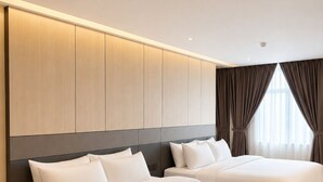 Habitación de hotel con dos camas, un armario grande y vistas al exterior.