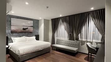 Deluxe King | Minibar, in-room safe, blackout curtains, iron/ironing board