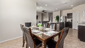 Un espace repas moderne avec une table en bois dressée pour six personnes, entourée de chaises en cuir.