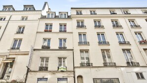 A multi-story building with a classic architectural style, featuring symmetrical windows and balconies. - Studio Vivienne - Welkeys (Paris)