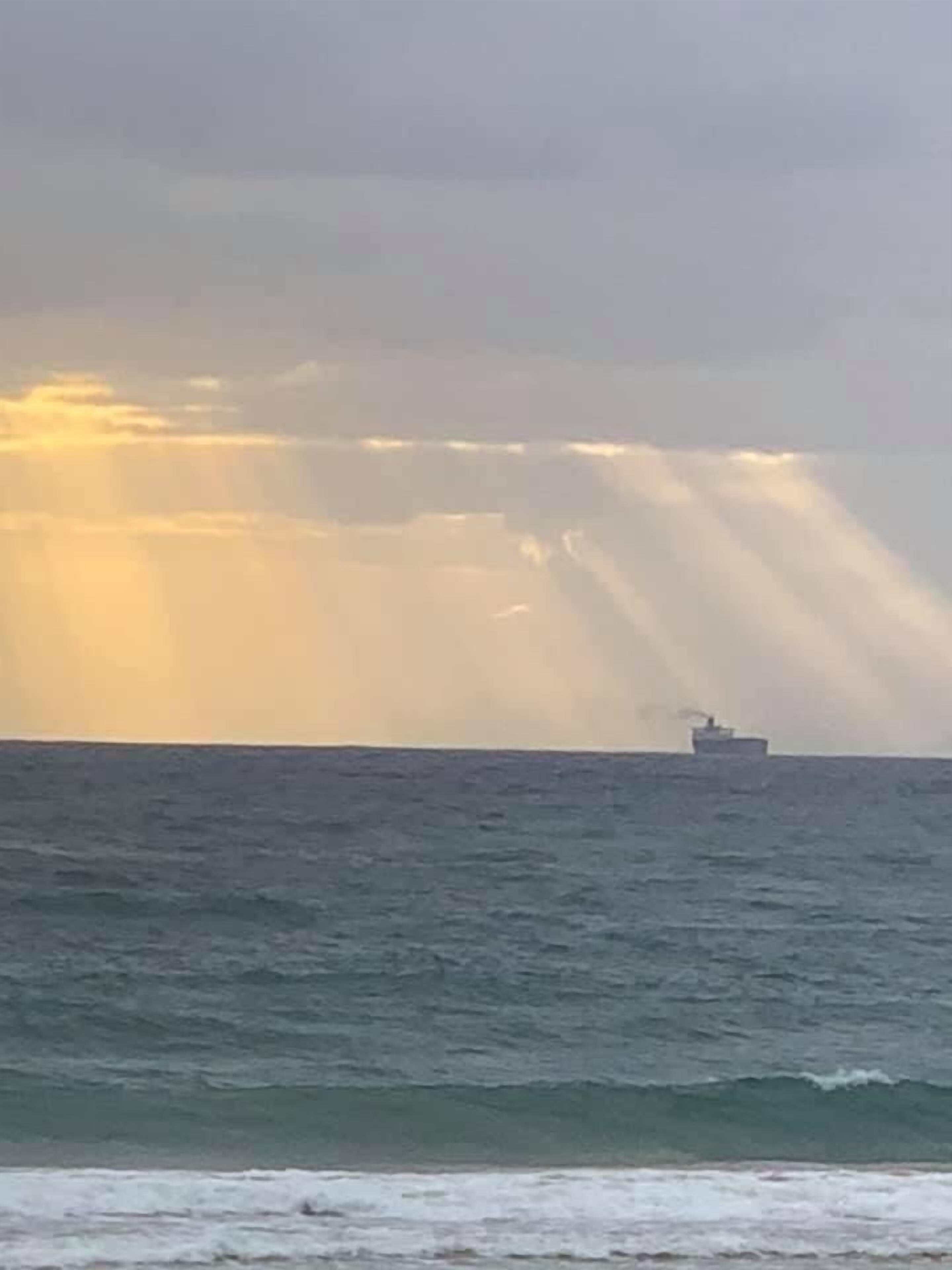 Un navire sur l’océan, sous un ciel nuageux.