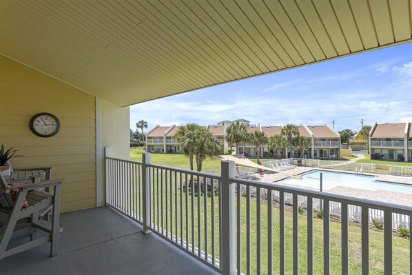 A balcony with a view of a swimming pool and adjacent buildings. - 8G, Endless Summer (Destin)