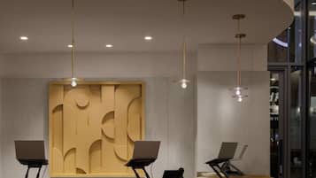 Una recepción con detalles de madera, dos sillas y un moderno artefacto de iluminación.