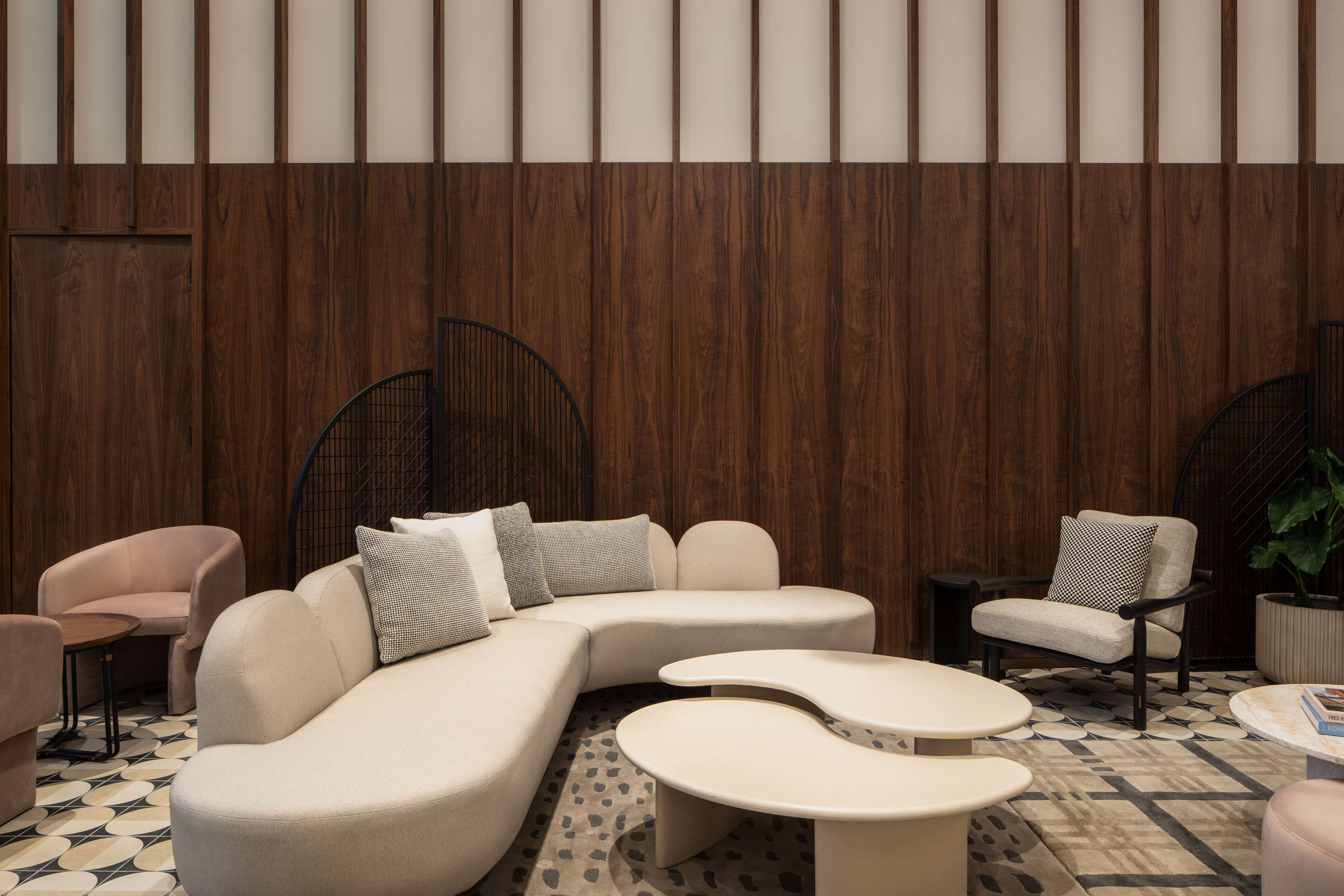 A modern lounge area with a sectional sofa, armchairs, and a coffee table.