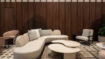 A modern lounge area with a sectional sofa, armchairs, and a coffee table.
