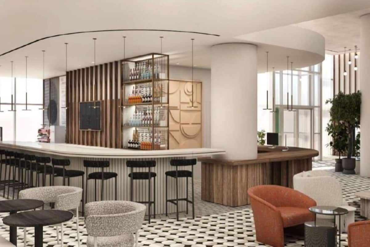 A modern bar area with stools, a counter, and a decorative wall.