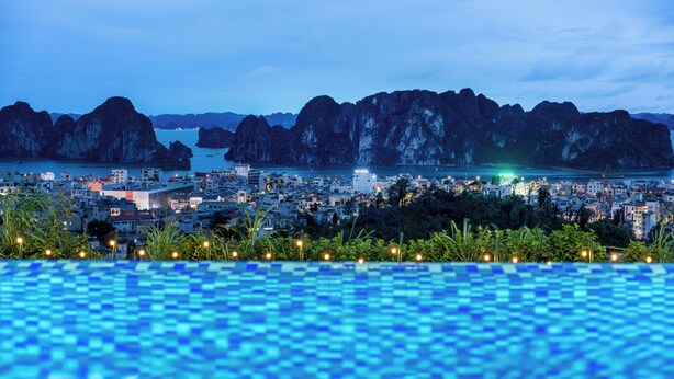 A view of a coastal city with a swimming pool in the foreground and rocky cliffs in the background. - Indochine‑Style Private Pool Villa Full Bay View |5 BR | Karaoke • Billiards (Thành phố Hạ Long)