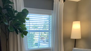 A room with a window, a lamp, a chair, a bench, and a potted plant. - CHARMING...COMFORTABLE...CONVENIENT (Denton)