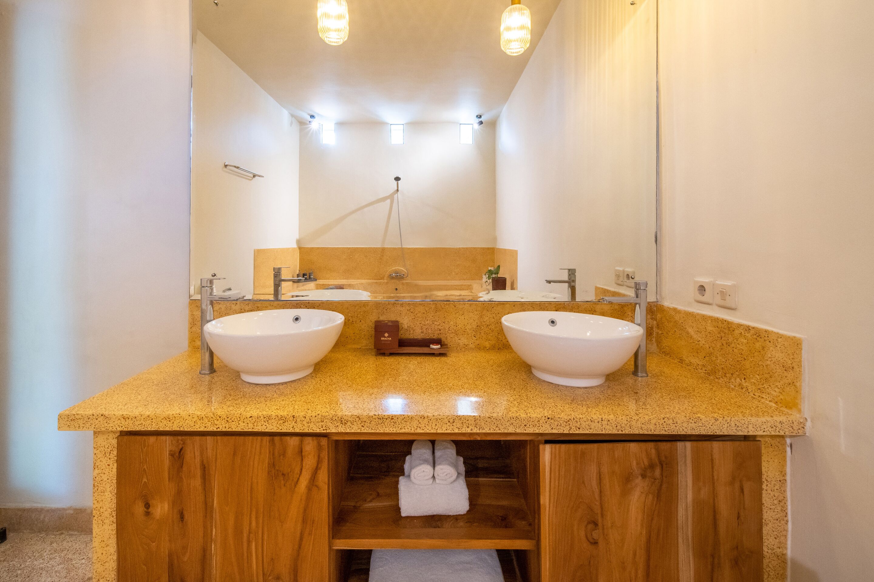 Un baño con dos lavamanos, un tocador de madera y un espejo.