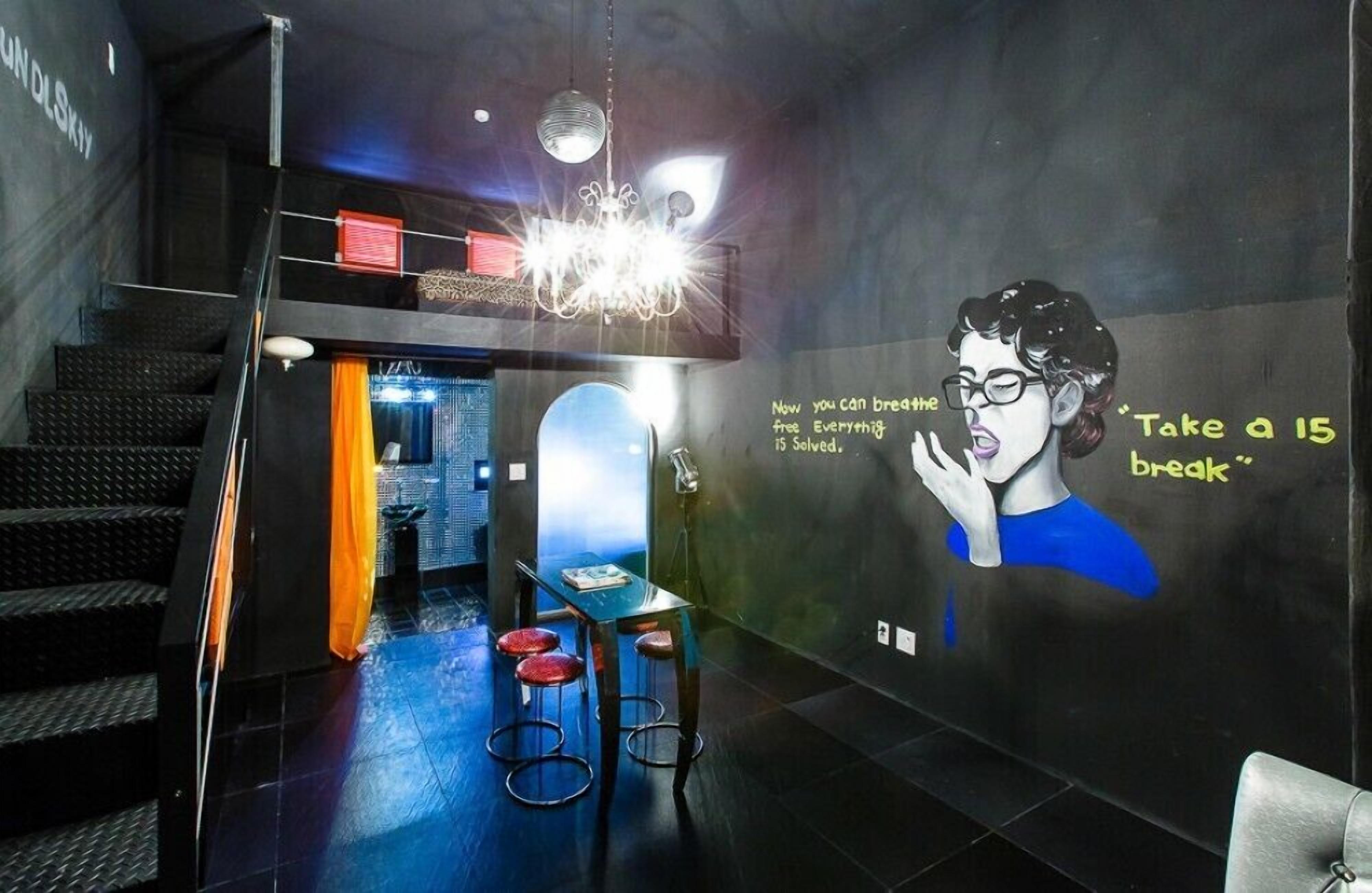 A modern interior with a staircase, a bar area, and a wall with a mural.