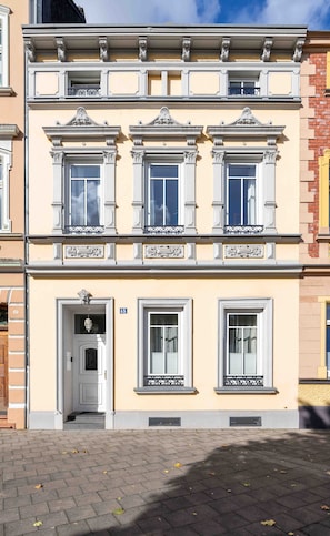 A multi-story building with a classic architectural style, featuring ornate window frames and decorative moldings.