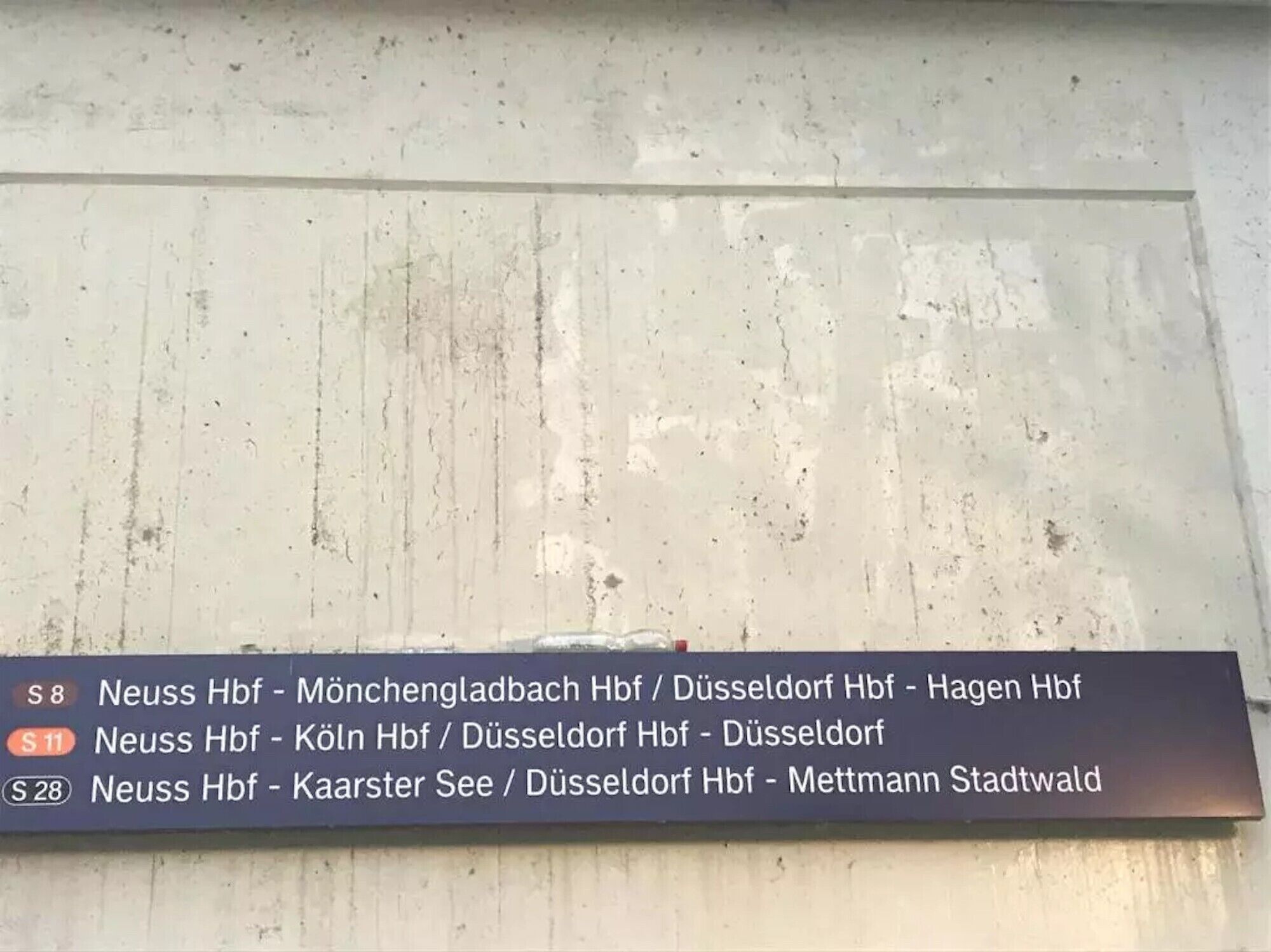 Een bord met route-informatie voor Neuss Hbf.
