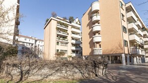 A multi-story residential building with balconies, a paved courtyard, and a clear sky. - Via Marcona 17 Apartment (Milano)