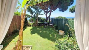 A well-maintained garden with a lawn, a large tree, and a view of the sea. - Mediterranean house with SEA VIEWS, garden and terrace. (Sant Feliu de Guíxols)