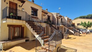 A row of terracotta-roofed buildings with balconies and a central staircase. - Mediterranean house with SEA VIEWS, garden and terrace. (Sant Feliu de Guíxols)