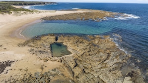 A coastal landscape with clear blue waters, rocky shorelines, and a sandy beach. - Ingenia Holidays Cape Paterson (Cape Paterson)
