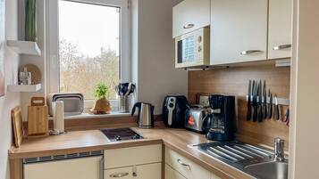 Eine moderne Küche mit integriertem Mikrowellenherd, Toaster, Kaffeemaschine und Spüle.