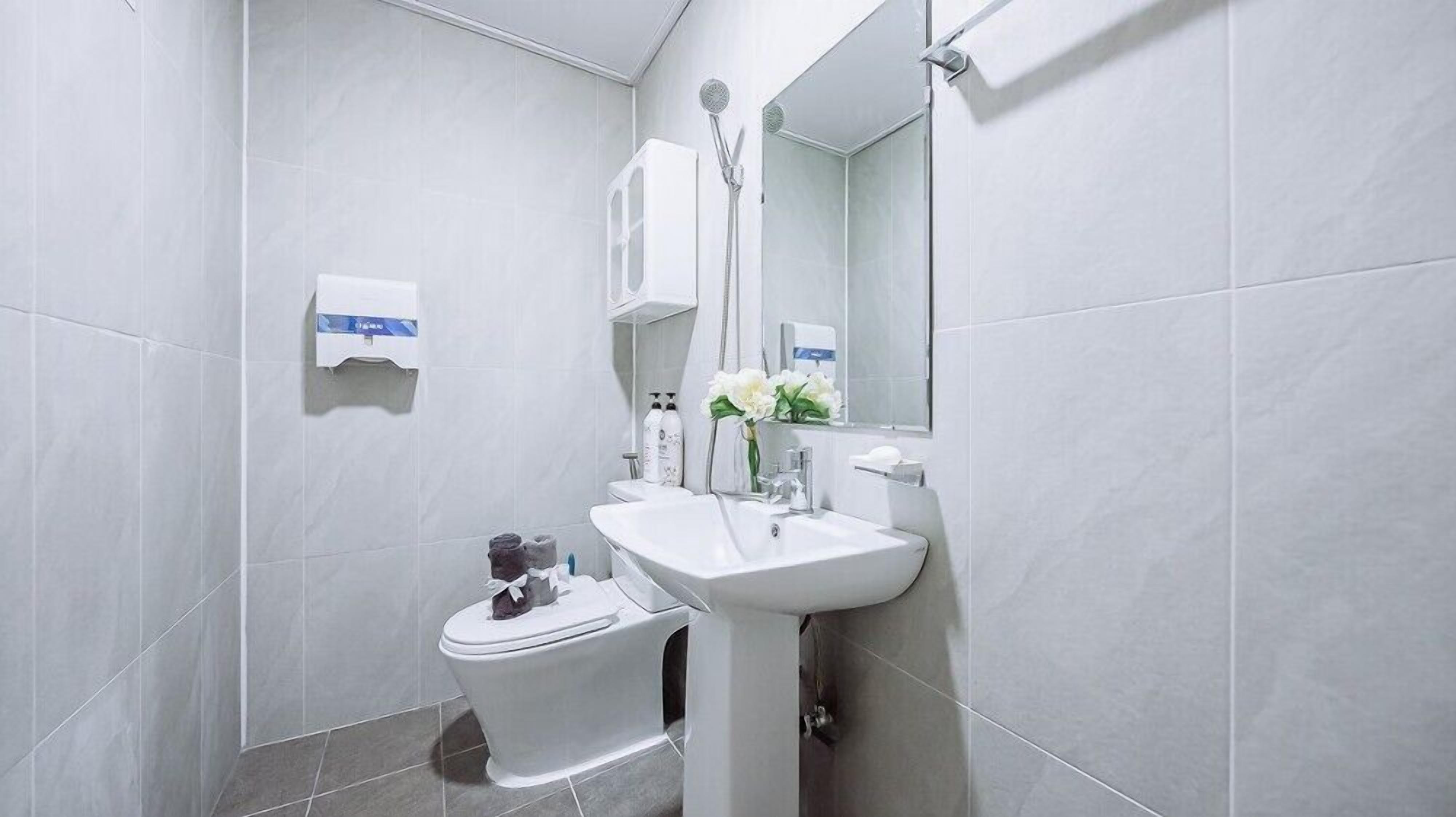 Une salle de bain moderne équipée de toilettes, d’un lavabo et d’une douche.