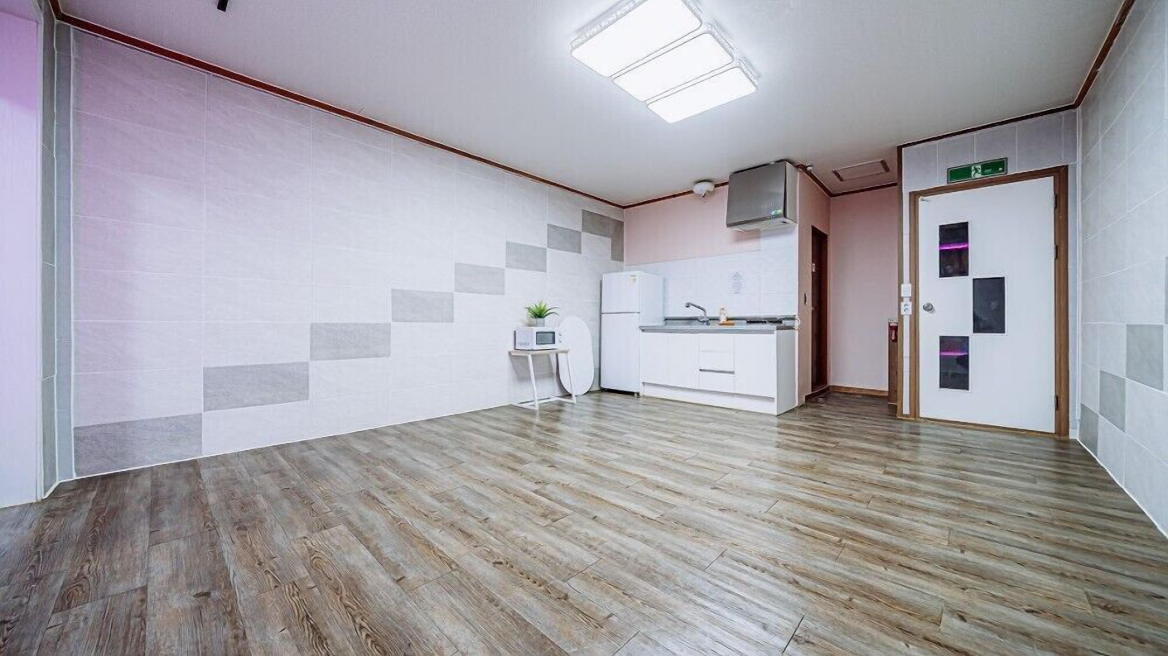 A modern kitchen with white cabinets, a microwave, and a refrigerator.